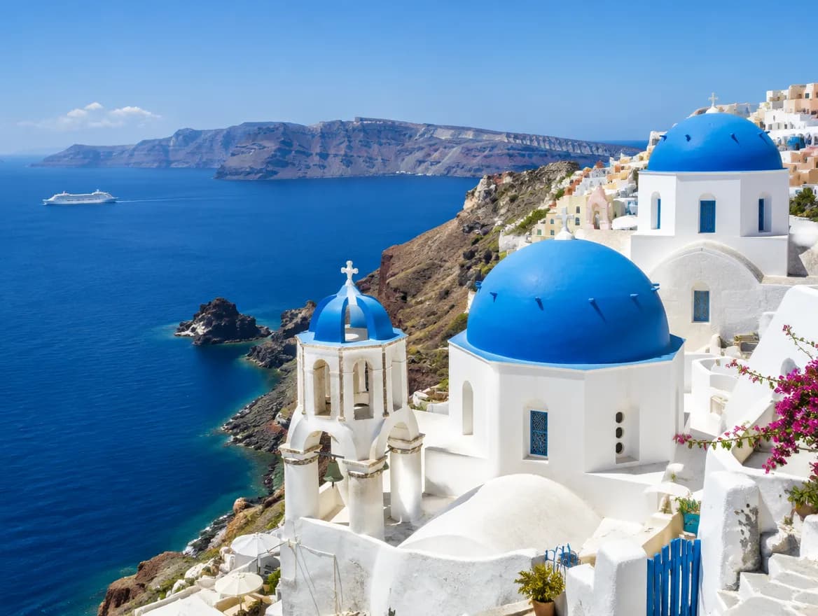 Whitewashed village with blue domes above the Aegean Sea